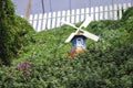 Miniature windmill made from wood surrounded by green nature