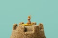 Miniature woman on a sandcastle