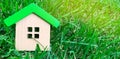 Miniature wooden house on grass. Real estate concept. Eco-friendly and energy efficient house. Buying a home outside the city. The Royalty Free Stock Photo