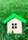 Miniature wooden house on grass. Real estate concept. Eco-friendly and energy efficient house. Buying a home outside the city. The