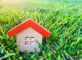 Miniature wooden house on grass. Real estate concept. Eco-friendly and energy efficient house. Buying a home outside the city. The Royalty Free Stock Photo