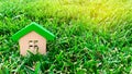 Miniature wooden house on grass. Real estate concept. Eco-friendly and energy efficient house. Buying a home outside the city. The Royalty Free Stock Photo