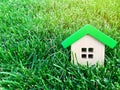 Miniature wooden house on green grass. Real estate concept. Eco-friendly and energy efficient house. Buying a home outside the Royalty Free Stock Photo