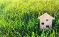 Miniature wooden house on green grass. Real estate concept. Modern housing. Eco-friendly and energy efficient house. Buying a home Royalty Free Stock Photo