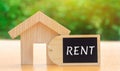 A miniature wooden house and inscription Rent. The concept of rental housing. Rent an apartment or house. Payment for renting.