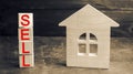 Miniature wooden house and the inscription ` Sell `. real estate concept. sell of a home, apartment property sell. Affordable hous