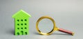 Miniature wooden house and magnifying glass. Home appraisal. Property valuation. House searching concept. Choice of location for Royalty Free Stock Photo