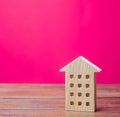 Miniature wooden house on a pink background. Sweet Home concept. Buying and selling real estate. Affordable housing for young