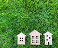 Miniature wooden houses on green grass. Real estate concept. Modern housing. Eco-friendly and energy efficient house. Buying a Royalty Free Stock Photo