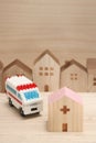 Miniature houses, hospital and ambulance on wood.