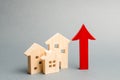 Miniature wooden houses and red arrow up. The concept of increasing the cost of housing. High demand for real estate. The growth Royalty Free Stock Photo