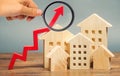 Miniature wooden houses and red arrow up. The concept of increasing the cost of housing. High demand for real estate. The growth Royalty Free Stock Photo
