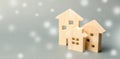 Miniature wooden houses and snowflakes. Demand for real estate in the winter. Christmas discounts and sale. Rental of housing.