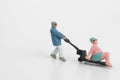 Miniature worker carrying a fat sunbathing man Royalty Free Stock Photo