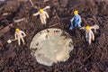 Miniature worker people found gold bitcoin in soil agricultural