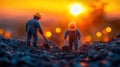 Miniature workers digging at sunset Royalty Free Stock Photo