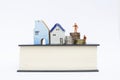 Miniature workers and house with stack of coins on thick book isolate on white backgroun Royalty Free Stock Photo