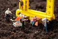 Miniature workmen building a house