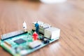 miniatures of people on a green electronic board. Relationship between man and technology, abstract concept with miniature Royalty Free Stock Photo