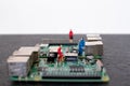 miniatures of people on a green electronic board. Relationship between man and technology, abstract concept with miniature Royalty Free Stock Photo
