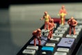 Miniatures of workers fixing a remote control Royalty Free Stock Photo