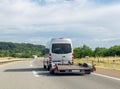 Minibus with empty tow truck transporter on highway. Space for text Royalty Free Stock Photo