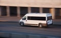 Minibus goes on city road Royalty Free Stock Photo