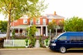 Minibus taxi van parked outside a house in a wealthy neighborhood