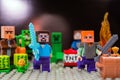 Minifigure Steve with diamond sword and Alex run away from the Creeper. Characters of the game Minecraft