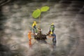 Miniiature people planting a tree