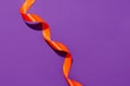 Minimal abstract Halloween background - orange satin tape on violet, copy space, flyer for your seasonal Holiday promotion company