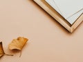 Minimal aesthetic composition with golden tray and whitre cards and two yellow leaves on beige background