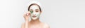 Minimal beauty portrait woman applying white nourishing mask or creme on face, green leaf in hand. banner Royalty Free Stock Photo