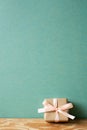 Minimal brown gift box on wooden table. green wall background. copy space