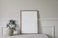 Minimal Christmas Scandinavian interior. Winter art display. Front view of blank vertical wooden picture frame, poster