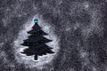 Minimal Christmas tree with sugar snow on dark background.