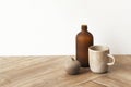 Minimal coffee cup by a brown vase on wooden floor Royalty Free Stock Photo