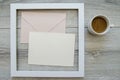 Minimal composition flatlay with a cup of coffee in white wooden frame and mockup and copyspace pastel pink envelopes Royalty Free Stock Photo