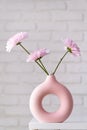 minimal composition of pink Scandinavian vase with purple daisies, interior decoration Royalty Free Stock Photo