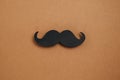 Minimal composition with retro stylish black paper photo booth props moustaches on brown background copy space.