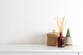 Scandinavian nordic hygge style, home interior - candle, scent aroma diffuser, small straw basket, white shelf Royalty Free Stock Photo