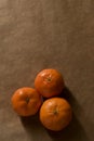 Minimal composition - Three clementines on brown paper