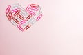 Minimal concept. Heart symbol made of stationery clips on pink background. Flat lay, top view