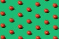 Minimal concept made of tomato pattern on green background. Red tomatoes pop art composition. Trendy vegetable. Flat lay