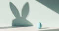 Minimal Easter composition with a blue decorated egg casting a bunny shadow on the wall. Creative spring background symbolizing Royalty Free Stock Photo