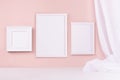 Minimal elegant gallery for display portfolio - three blank rectangle photo frames with flow silk curtain hanging on pink wall. Royalty Free Stock Photo
