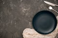 Minimal empty black plate mockup, fork, knife and copy space on rustic dark grey background Royalty Free Stock Photo