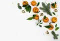Minimal flat lay Christmas composition of fir tree branch, tangerine and gold balls on white Royalty Free Stock Photo
