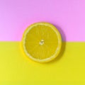 Minimal food concept. Lemon on a bright yellow-pink background. Free space for text. Top view. Minimalism. Creative citrus fruits