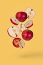 Minimal fruit idea with fresh sliced and whole apple floating in the air isolated on pastel yellow background Royalty Free Stock Photo